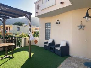 eine Terrasse mit grünem Rasen, Stühlen und einem Tisch in der Unterkunft Villa Marina in Orosei