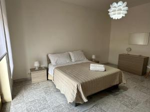 a bedroom with a bed and two night stands and a chandelier at Rifugio tra Etna e mare in Mascali