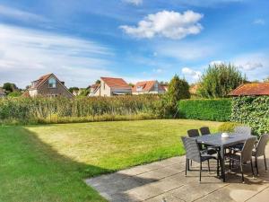 Un patio con una mesa y sillas en un patio. en Bungalow in Breskens near Beach and Dunes, en Breskens