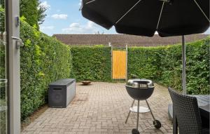um pátio com um grelhador, um fumador e um guarda-chuva em Cozy Apartment In Middelfart With Wifi em Middelfart mais 2 fotografias