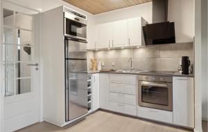uma cozinha com armários brancos e eletrodomésticos de aço inoxidável em Cozy Apartment In Middelfart With Wifi em Middelfart