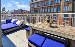 a balcony with a wooden table and benches on a building at Lovely Apartment In Oostende With Wifi in Ostend