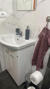a white bathroom with a sink and a mirror at M&O Belgrade in Belgrade