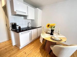 a kitchen with a table and a kitchen with white cabinets at Studio Centre Ville COTY in Le Havre