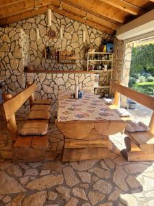 un patio con una mesa y una pared de piedra en Apartment Maria, en Pirovac