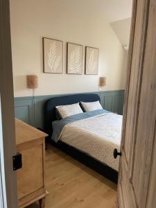 a bedroom with a bed with four pictures on the wall at La ferme des peupliers in Estaires