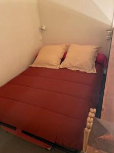 a bed with two pillows on it in a room at Petit chalet cosy prêt des pistes in Bolquere Pyrenees 2000