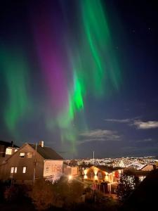 an aurora in the sky over a city at Cozy 1 bedr apartment close to everything! in Tromsø