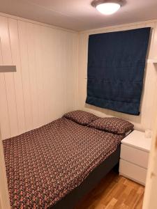 a small bedroom with a bed and a blue curtain at Cozy 1 bedr apartment close to everything! in Tromsø