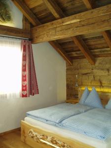 a bedroom with a bed in a room with wooden ceilings at Alpenchalets Weissenbacher-Fuchsbau in Tamsweg