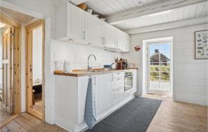 a kitchen with white cabinets and a sink at 3 Bedroom Gorgeous Home In Blåvand in Blåvand