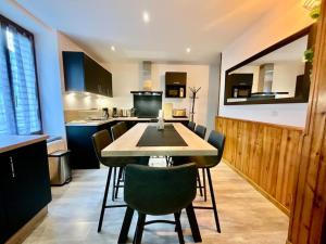 a kitchen with a table and chairs in a room at Gîte des Randonneurs, jardin & BBQ et borne VE in Gérardmer +7 photos