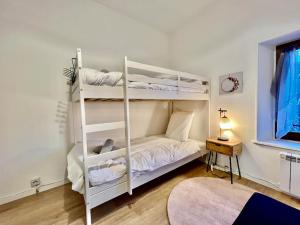 a white bunk bed in a room with a window at Gîte des Randonneurs, jardin & BBQ et borne VE in Gérardmer