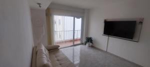 Una sala de estar con un sofá y un televisor de pantalla plana. en Kattegat, en Puerto Madryn