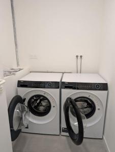 two washing machines sitting next to each other in a room at écrin de lumière à 10 min de l'hypercentre in Strasbourg +3 photos