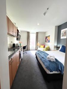 a bedroom with a bed and a kitchen with a sink at 303 Cheerful City Central Crib Sleeps 2 in Perth