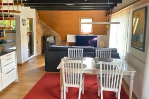 a kitchen and dining room with a table and chairs at Haus Löwe - Komplettes Ferienhaus am Badesee in Erzgrube