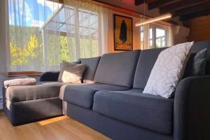 a blue couch in a living room with windows at Haus Löwe - Komplettes Ferienhaus am Badesee in Erzgrube