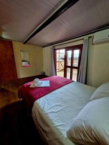 una camera da letto con un letto grande con una finestra di Apartamento duplex - 2 quartos na Pituba a Itacaré