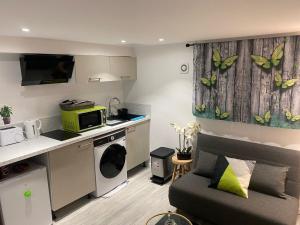 a small living room with a couch and a kitchen at Auxilia Home in Beauchamp