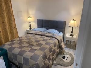 a bedroom with a bed with two night stands and two lamps at Auxilia Home in Beauchamp