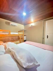 a bedroom with two beds and a bunk bed at Casa Dos Gringobz in Búzios