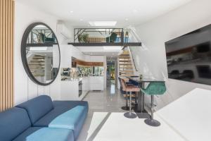 un salon avec un canapé bleu et un miroir dans l'établissement Village Naturiste R4N - La Villa GreenWood, au Cap d'Agde