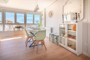 Una cocina con mesa y sillas y un refrigerador. en Santander Centro I 3 Hab I Wifi I Moderno, en Santander