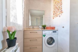Un baño con lavadora y lavabo. en Santander Centro I 3 Hab I Wifi I Moderno, en Santander