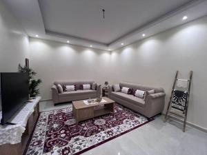 a living room with two couches and a tv at مسكن التل in Medina