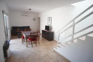 a living room with a table and chairs and a staircase at Moderno departamento caseros in Caseros