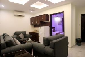 a living room with two couches and a refrigerator at شقق أمواج للشقق المخدومه in Al Jubail