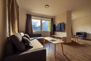 a living room with a couch and a window at Via Alpina Apartments with sauna in Mojstrana