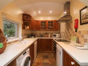 a kitchen with a sink and a washing machine at Goslings in Thornbury
