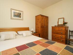 a bedroom with a bed and a dresser with a mirror at Goslings in Thornbury