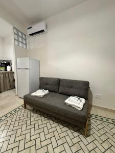 a couch sitting in a living room with a refrigerator at La Casetta in Trapani