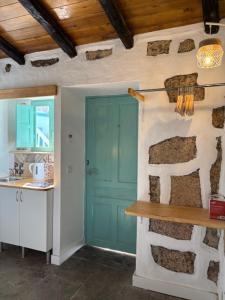 a kitchen with a blue door and a sink at Hacienda de las Indias, Costa Rica in Granadilla de Abona