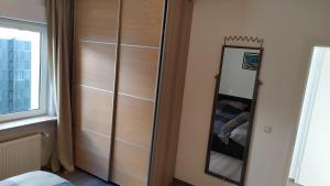 einen Holzschrank mit einem Spiegel im Zimmer in der Unterkunft Haus im Garten in der Nähe von Köln-Messe in Bergisch Gladbach