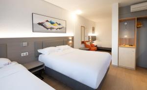 Postel nebo postele na pokoji v ubytování Hotel Tambourin