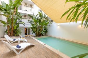 a pool with two lounge chairs and a swimming pool at Modern Beautiful Pool And Sea Apt Qawra - Happy Rentals in Qawra +36 photos