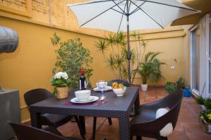 a table and chairs with an umbrella on a patio at SingularStays Botanico 29 Rooms in Valencia