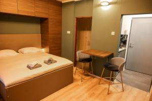 杜加雷萨BS Studio Apartman的一间卧室，配有一张床、一张桌子和几把椅子