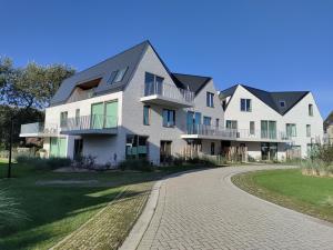 a large white house with a driveway at Vakantieappartement West Bay Westende in Middelkerke