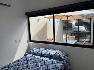a bedroom with a large window and a table with an umbrella at Casa Nueva con Alberca Puerto Vallarta in Puerto Vallarta +40 photos