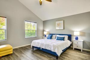 a bedroom with a blue bed and two windows at 7 Mi to Dwtn Portland - Home with Patio! in Beaverton