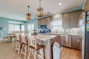 a kitchen with wooden cabinets and a kitchen island with bar stools at Captiva by Meyer Vacation Rentals in Gulf Shores