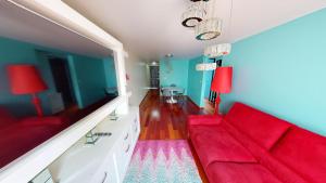 ein Wohnzimmer mit einem roten Sofa und blauen Wänden in der Unterkunft Bello departamento en Centro Histórico de la CDMX in Mexiko-Stadt