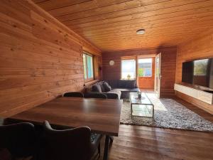 a room with a table and a couch and a tv at Gemütlich Wohnung im Schwarzwald in Weilheim