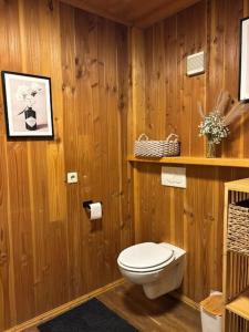 a wooden bathroom with a toilet and a shelf at Gemütlich Wohnung im Schwarzwald in Weilheim +7 photos