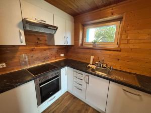 a kitchen with white cabinets and a sink and a window at Gemütlich Wohnung im Schwarzwald in Weilheim